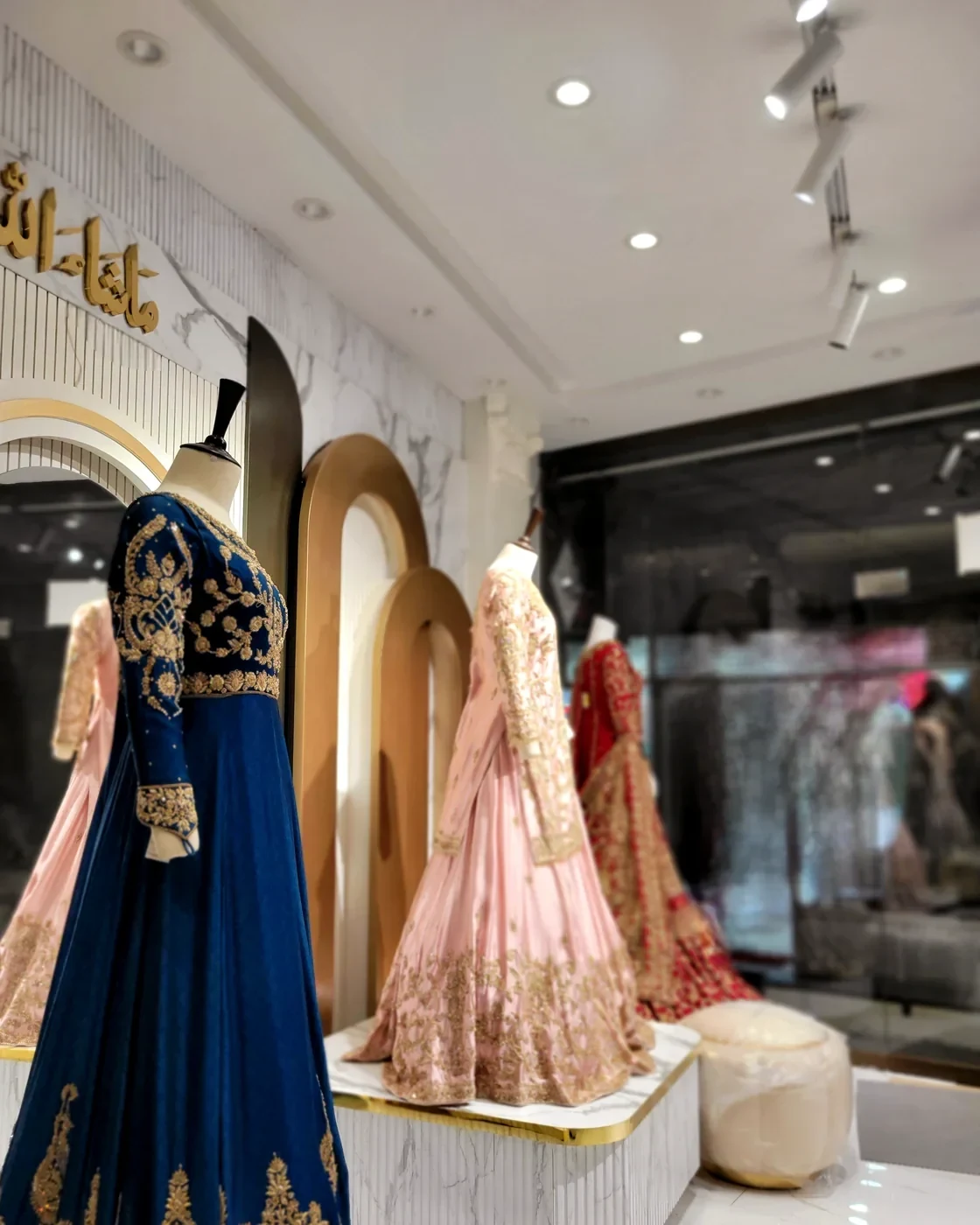 Finished bridal pieces on display in the Zauq studio, lit under gold arches